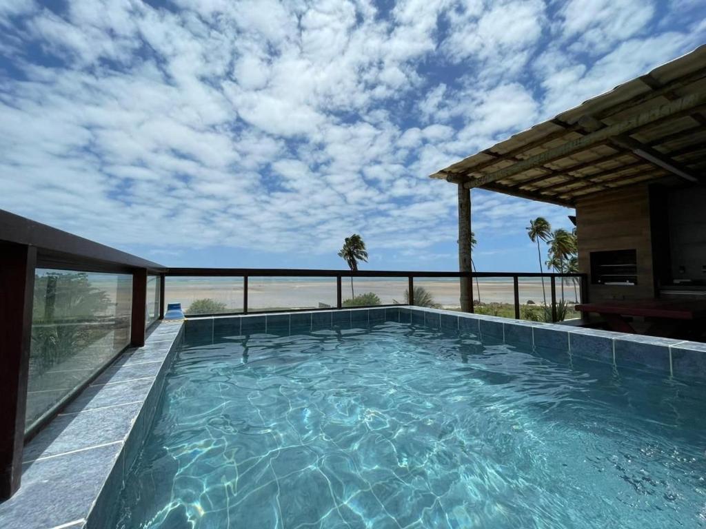 una piscina con vistas a la playa en Luxo Pé na Areia na Rota Milagres, en Tatuamunha