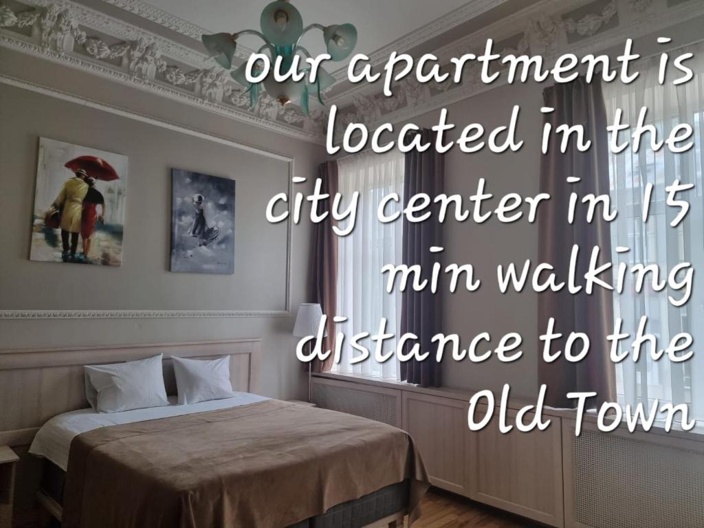 un dormitorio con una cama y una cita en City Inn Riga Apartment, Barons promenade with parking, en Riga