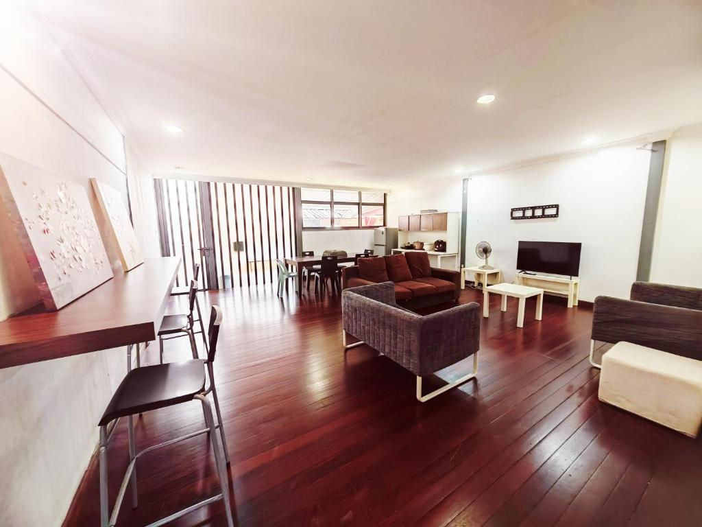uma sala de estar com um sofá e uma sala de jantar em Vivacity Staycation Home 6 Bedrooms em Kuching