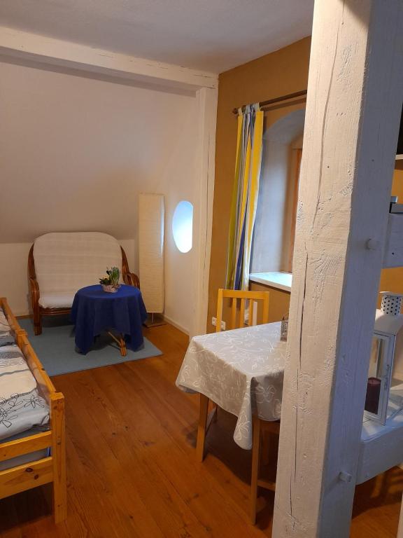 Cette chambre comprend une table, un lit et une fenêtre. dans l'établissement Gemütliche Ferienunterkunft direkt am Meer, à Holnis