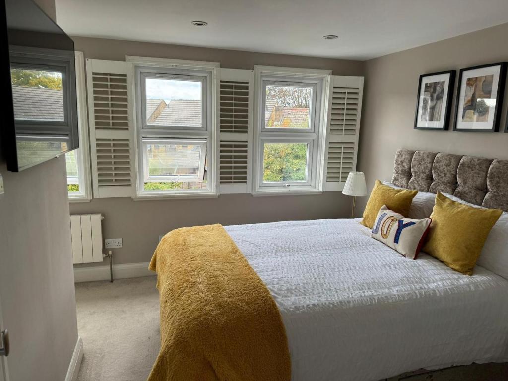 a bedroom with a large bed with windows at Brentford Guest Rooms in Brentford