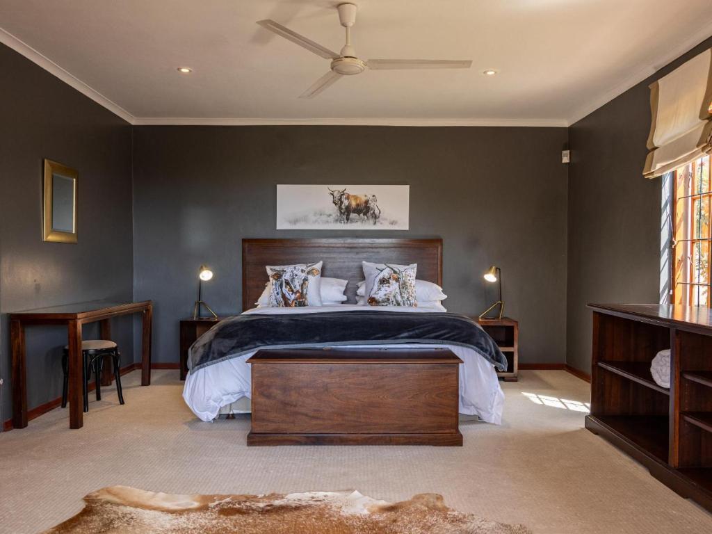 a bedroom with a large bed and a ceiling fan at Serenity Lodge in Clarens