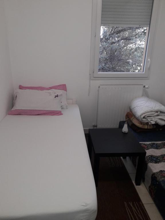 une petite chambre avec un lit et une fenêtre dans l'établissement Chambre-Room, à Montpellier