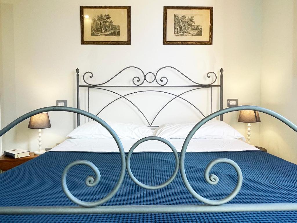 a bedroom with a metal bed with a blue comforter at Oliveta blu in Siena