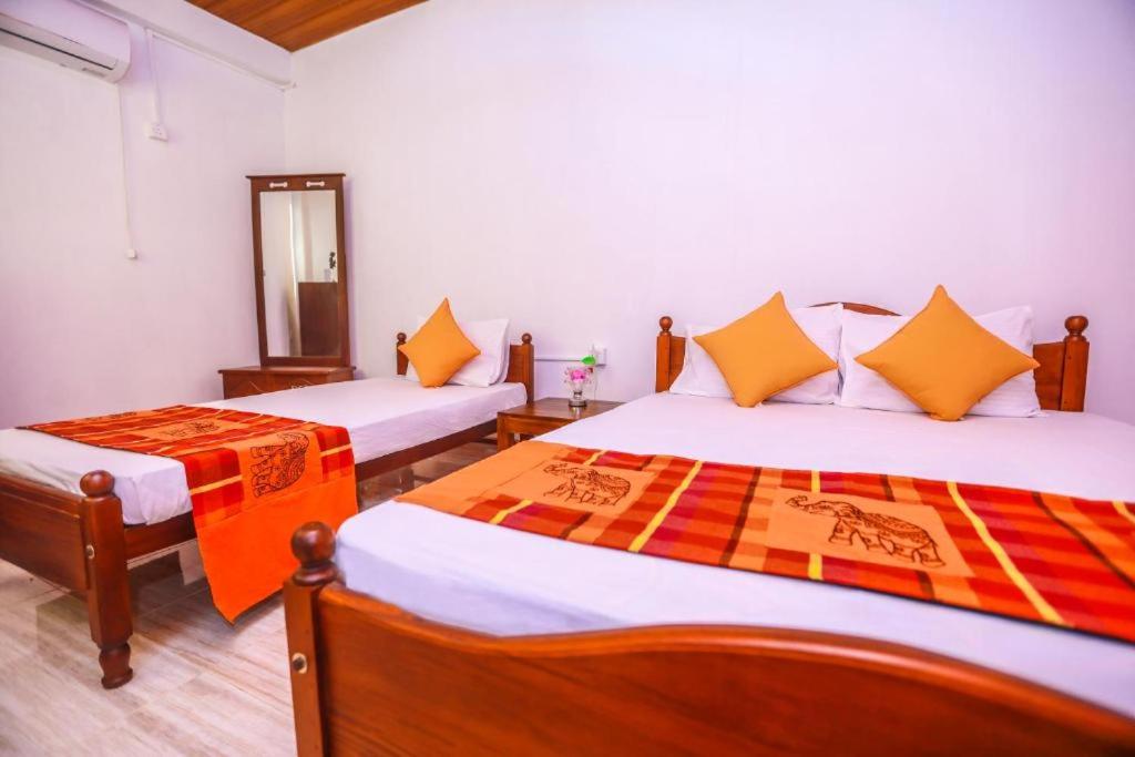 パナドゥラにあるSilverin Rest Apartmentのベッド2台と鏡のある寝室