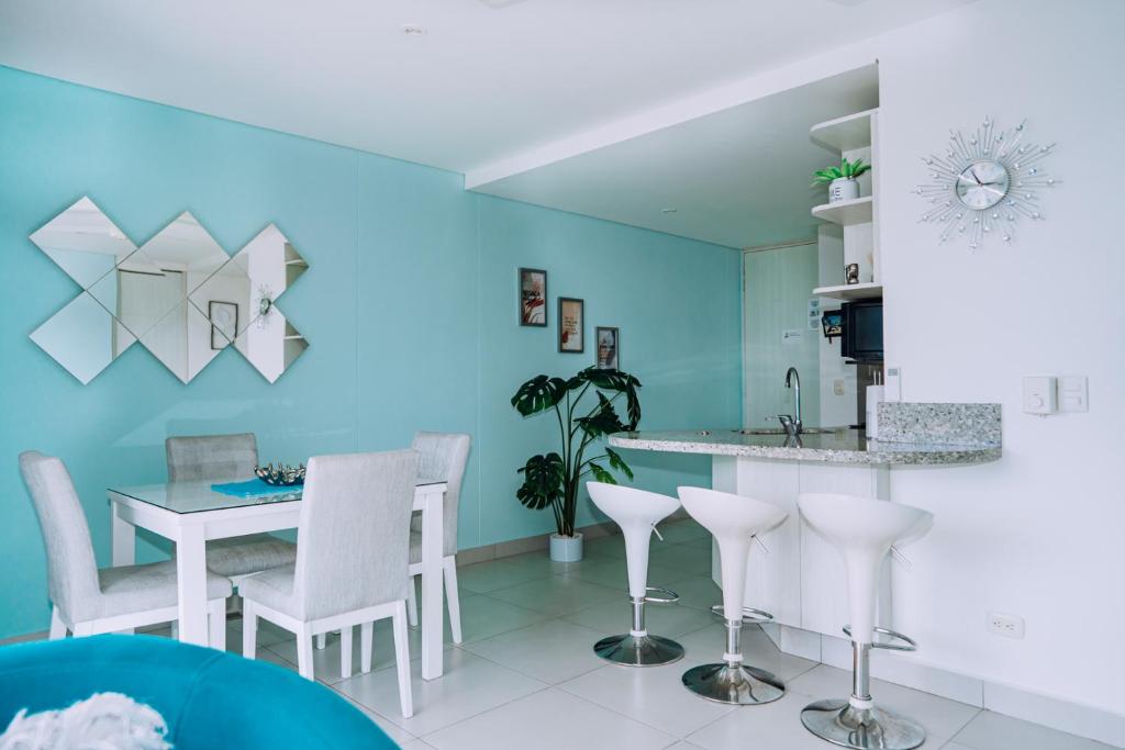 a kitchen with blue walls and a table and chairs at Apartamento - Velas al Mar, Santa Marta in Gaira