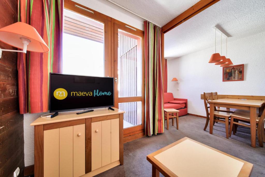 un salon avec une télévision et une salle à manger dans l'établissement Résidence Les Chalets des Arolles - maeva Home - Studio 4 Personnes - Confort MAE-5711, à Aime La Plagne