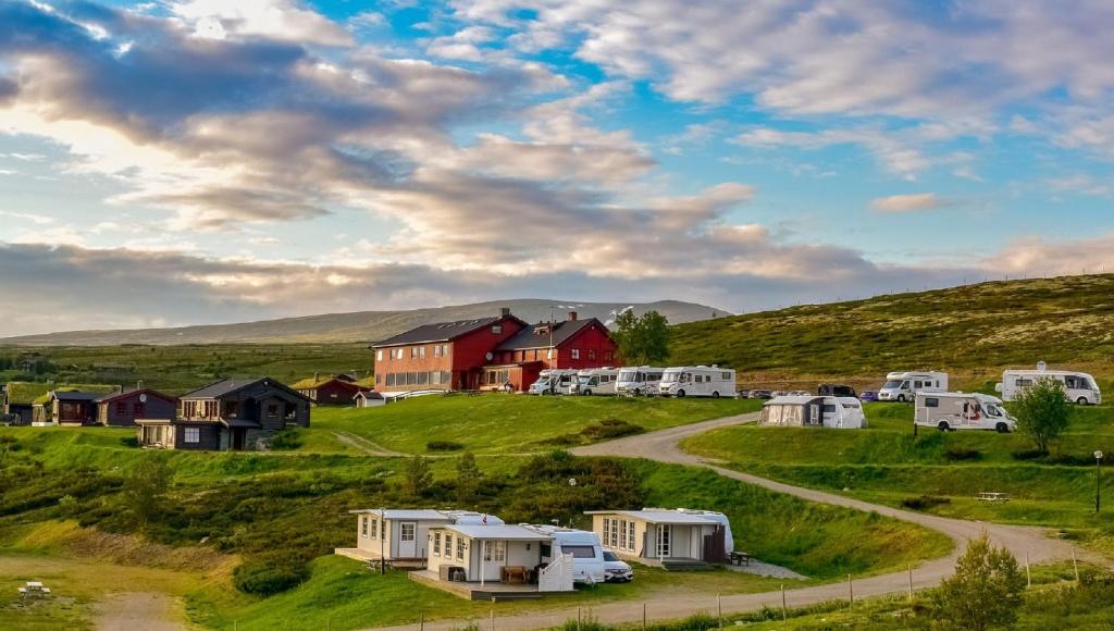 un grupo de casas y cabañas en un campo en Rondane Haukliseter Fjellhotell, en Høvringen