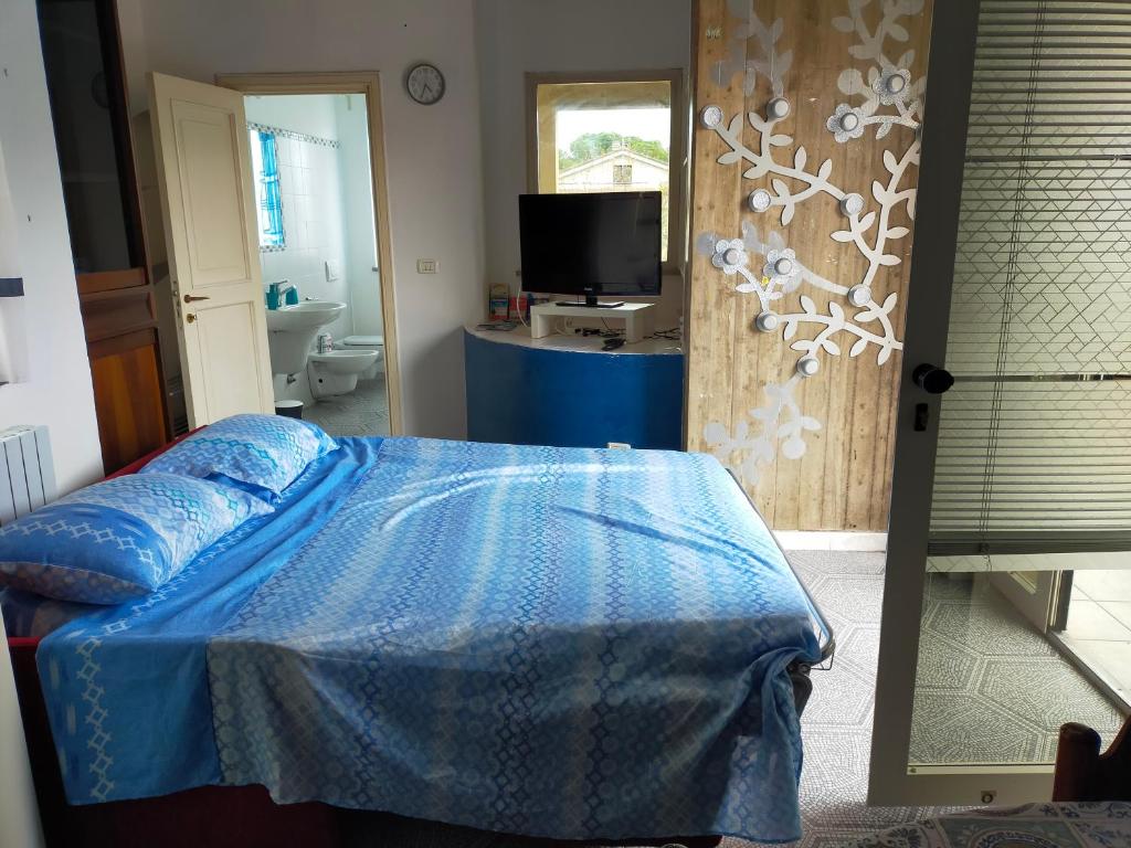 una camera con letto blu e televisore di Mini ma funzionale a Giulianova