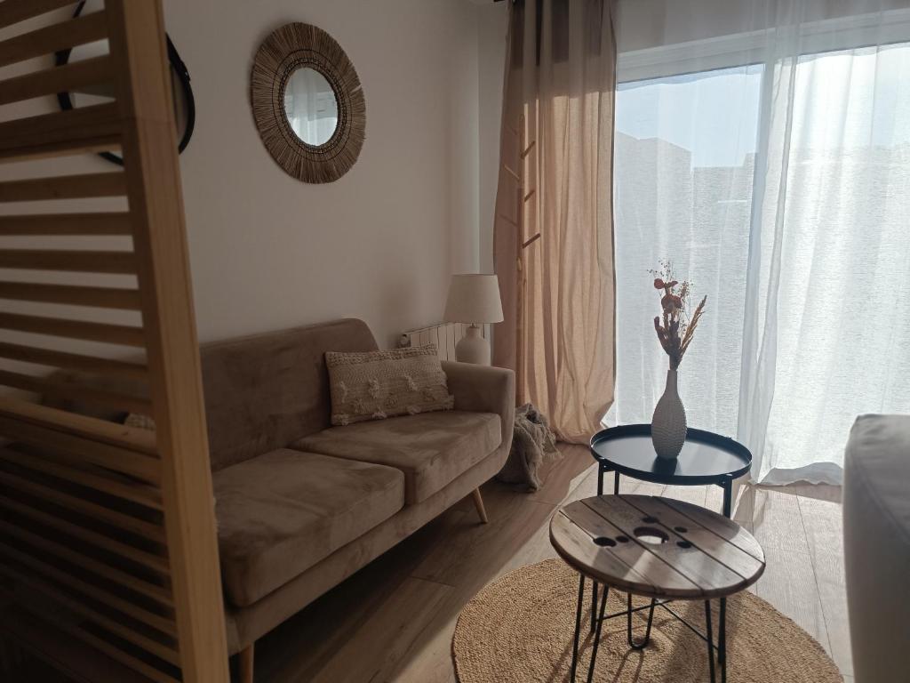 ein Wohnzimmer mit einem Sofa und einem Tisch in der Unterkunft La pause bretonne in Quéven