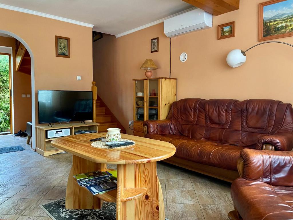 a living room with a leather couch and a table at Dvoupodlažní zděná chata in Tábor