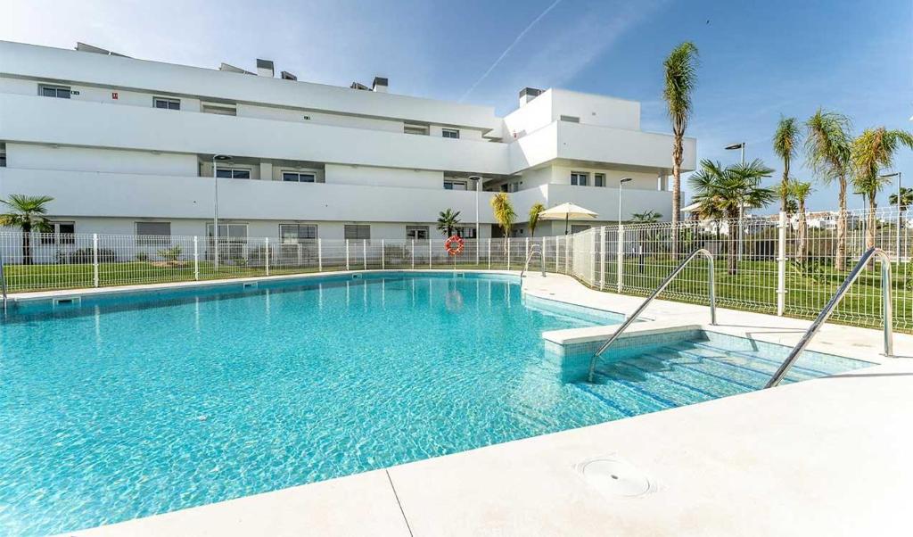 ein großes Schwimmbad vor einem Gebäude in der Unterkunft Ático Ceitil Candor in Rota