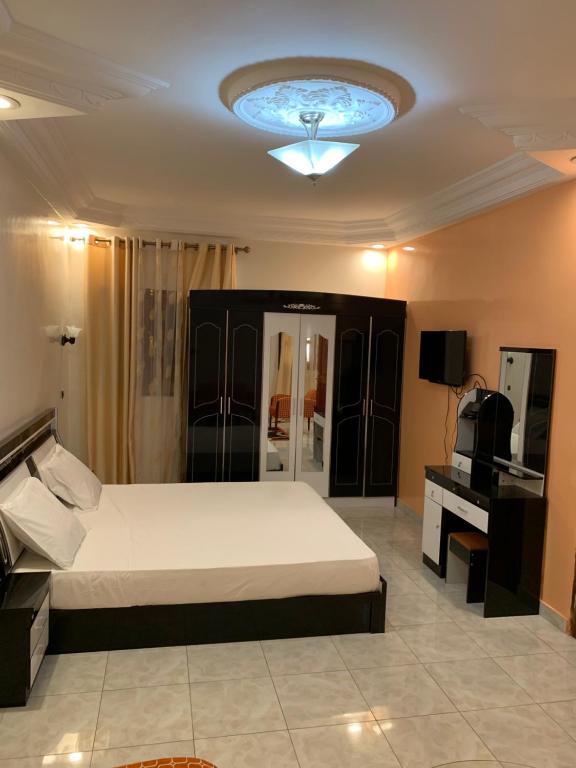 a bedroom with a bed and a ceiling with a light at Cabral résidence in Guediawaye