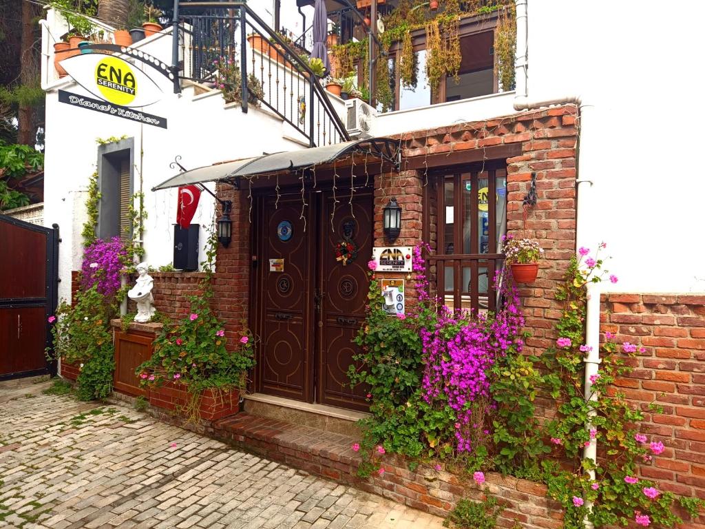 a brick building with a brown door and flowers at ENA Serenity Boutique Hotel Ephesus in Selçuk