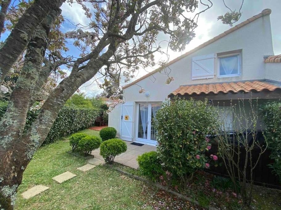 une maison blanche avec un arbre dans la cour dans l'établissement Aurora Surf Lodge maison Mer, à Saint-Vincent-sur-Jard