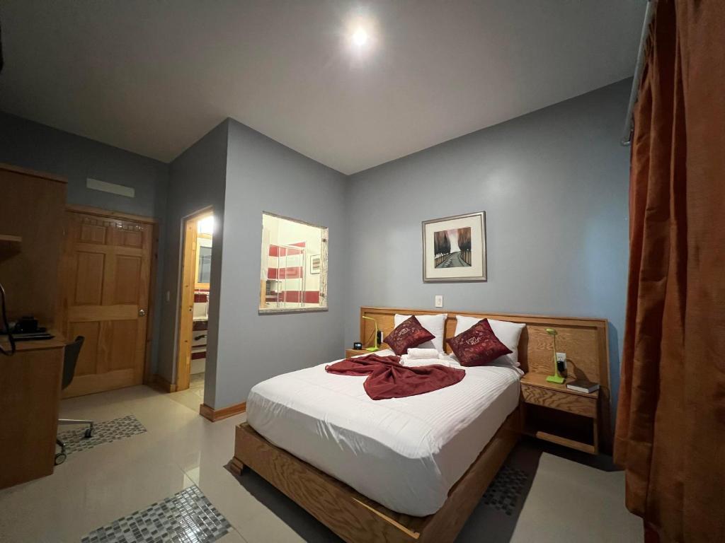 a bedroom with a bed with white sheets and red pillows at Spencer Residencial QUARTOS in Praia