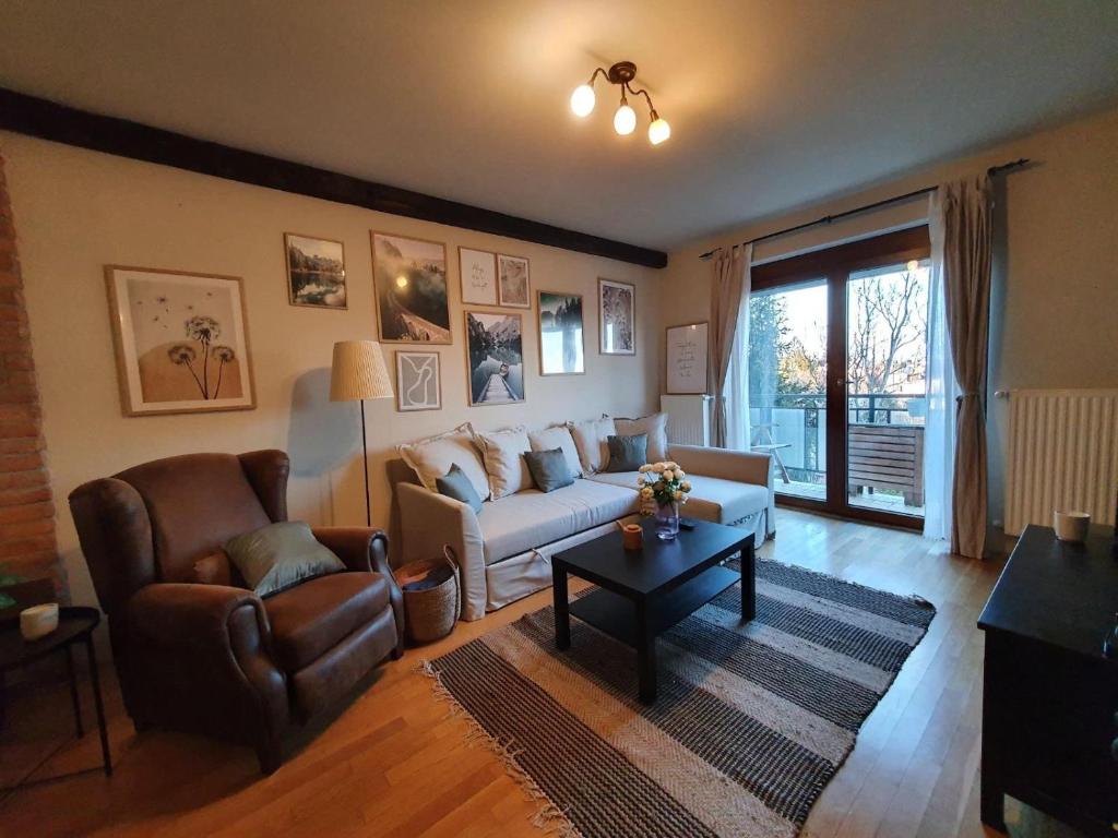 sala de estar con sofá y mesa en Bárány Apartman en Pécs