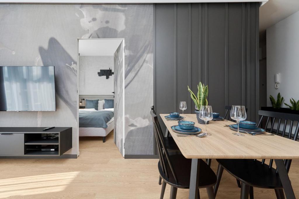 a dining room with a table and a bedroom at Ekskluzywny apartament w Porcie Popowice - Fair Rentals in Wrocław