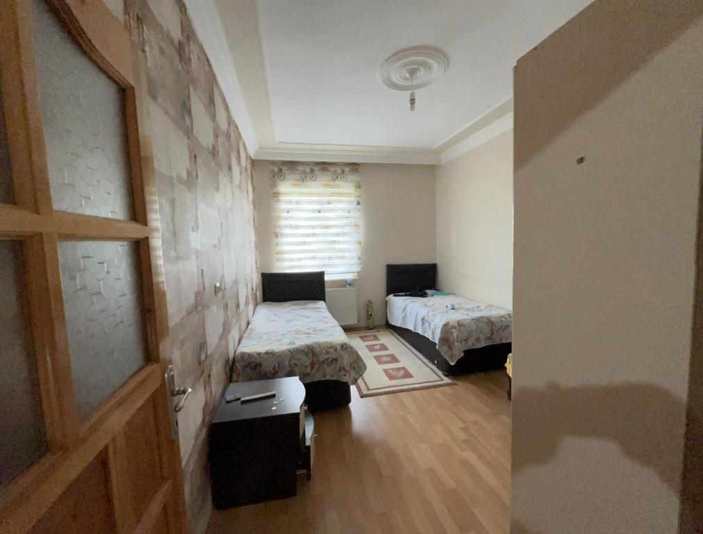 a small room with two beds and a window at MET house in Hacılar