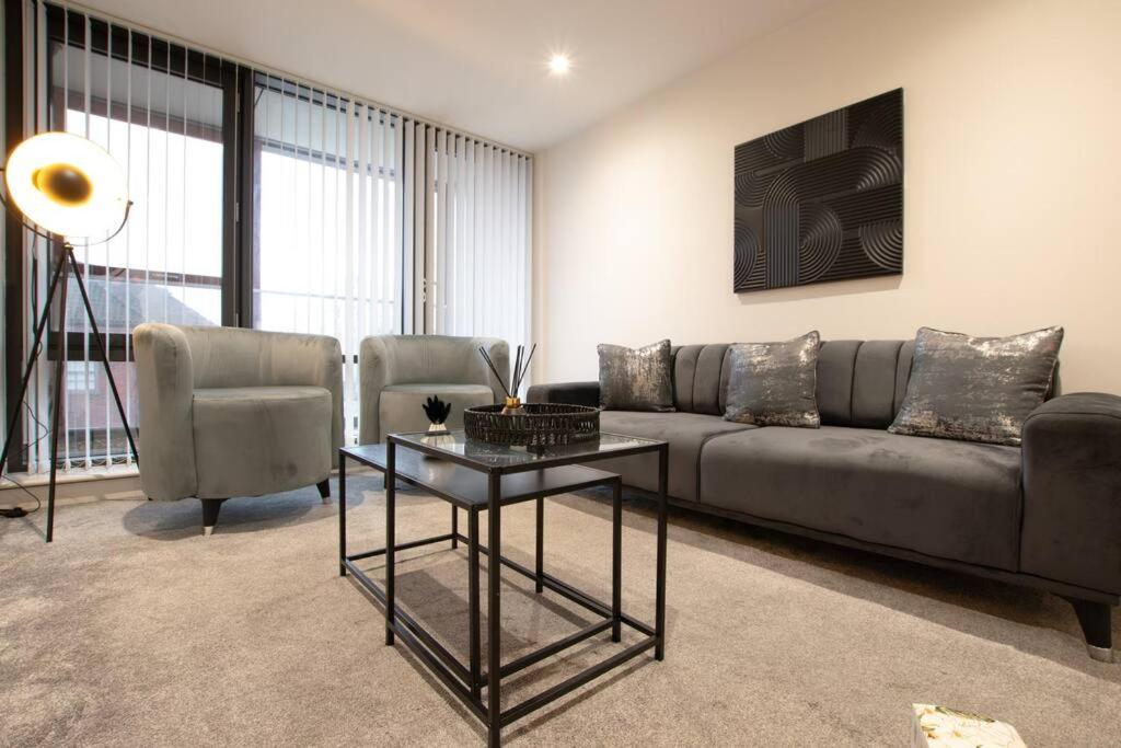 uma sala de estar com um sofá e duas cadeiras e uma mesa em Luxury City Centre Apartment (Weekly Booking) em Hull