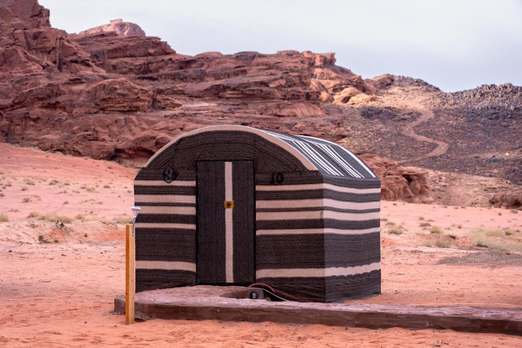 a small building in the middle of the desert at desert colored camp in Wadi Rum