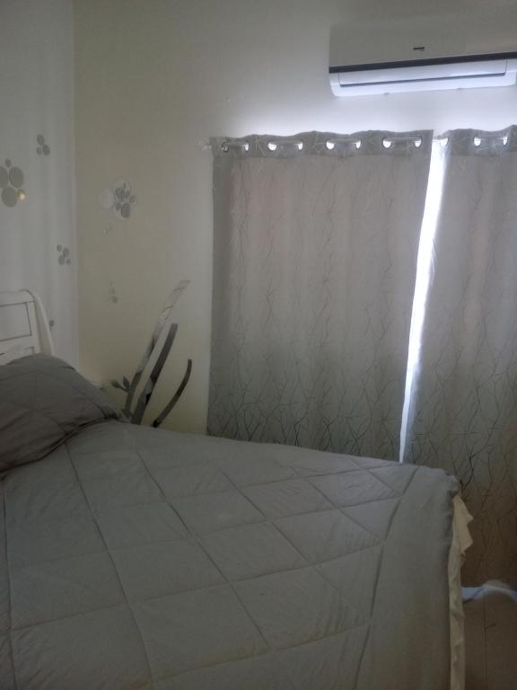 1 dormitorio con cama y ventana con cortina en 7hills comfort suites en Cooperʼs Town