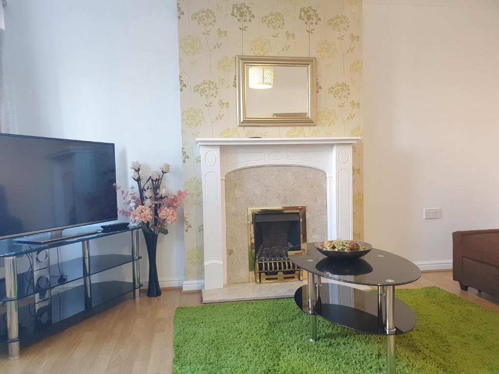 a living room with a fireplace and a television at Perfect Stay Manchester in Wythenshawe