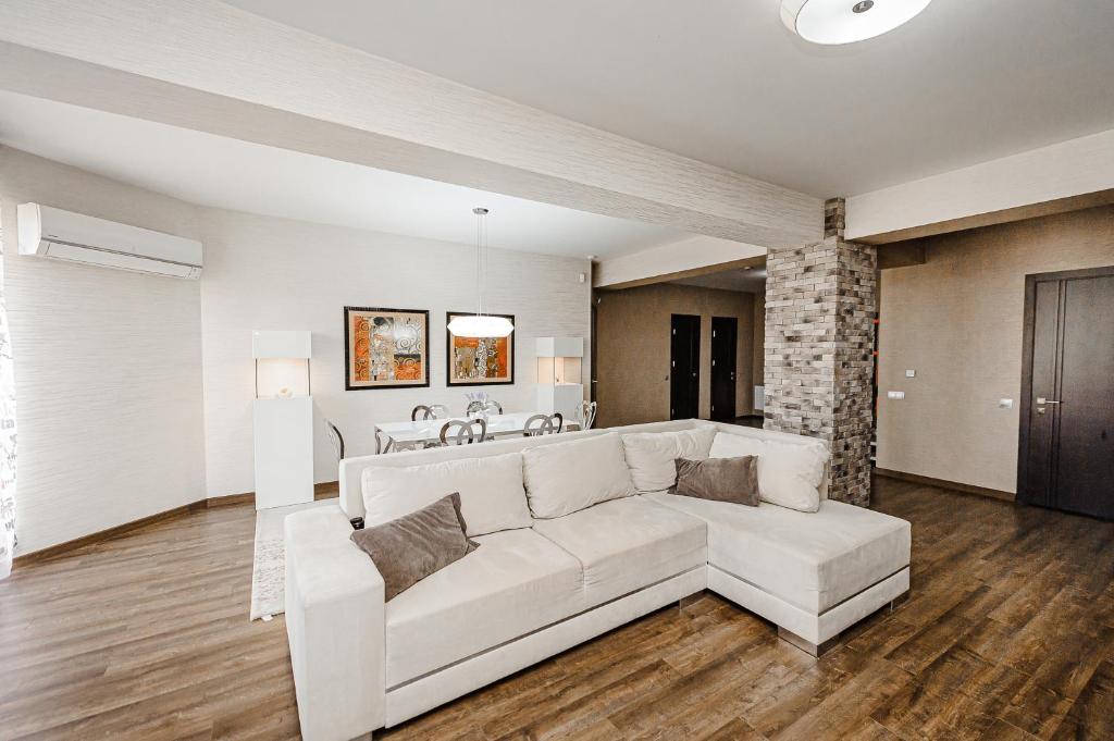 a living room with a white couch and a table at Spacious apartment close to Valea Trandafirelor park! in Chişinău