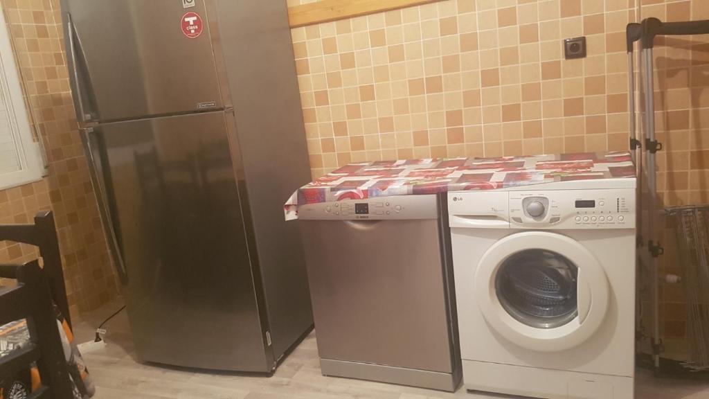 een keuken met een wasmachine en een koelkast bij Appartement spacieux meublé in Oujda