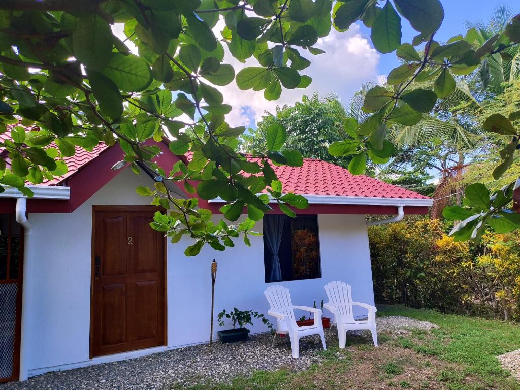 twee witte stoelen buiten een huis bij Casa Osa Azul in Puerto Jiménez