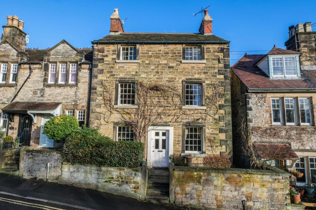 an old stone house in the middle of a street at Bakewell cottage in Bakewell