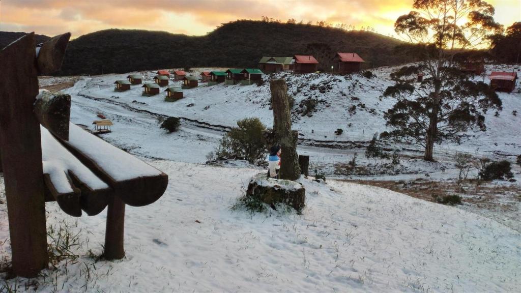 Costão do Cambará Pousada Fazenda في كامبارا: تل مغطى بالثلج مع حديقة على بعد مسافة