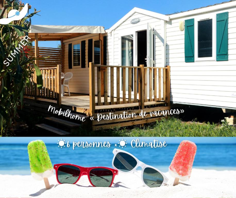 a pair of sunglasses on the beach next to a house at Mobilhome « Destination de vacances» in Sigean