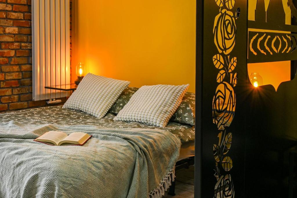 een slaapkamer met een bed met een boek erop bij Industrial Kato in Katowice
