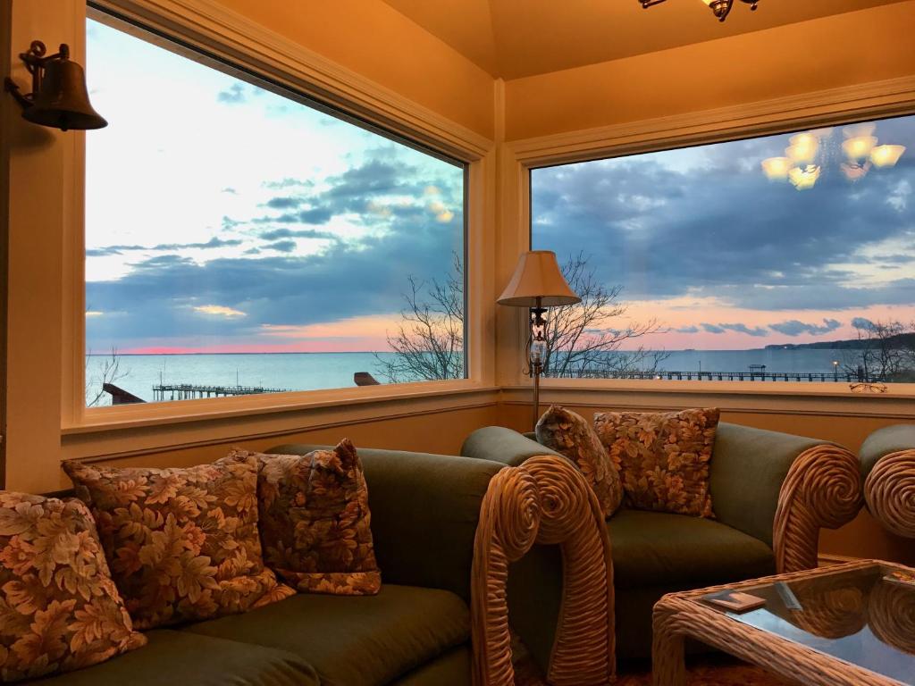 a living room with a couch and a large window at Chesapeake Bay Maryland Waterfront Home, Stunning Views 45 min from DC pier fossils hiking in Port Republic