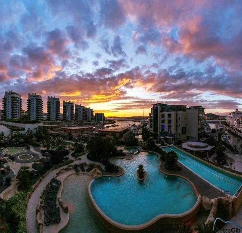 a view of a resort with a swimming pool at sunset at Britain in the Sun at Luxurious Ocean Village in Gibraltar