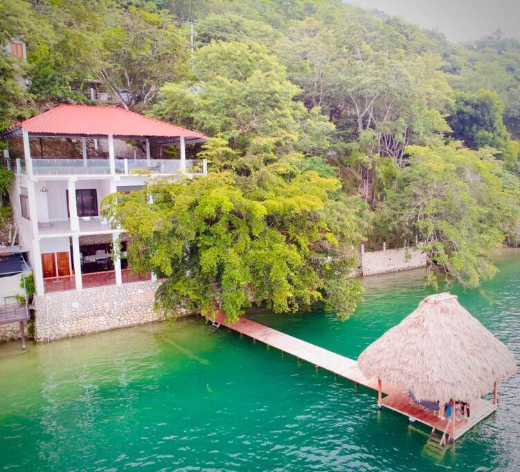 a house with a dock in the middle of the water at El Remate Panoramic View House 3 Levels Peten in Jobompiche