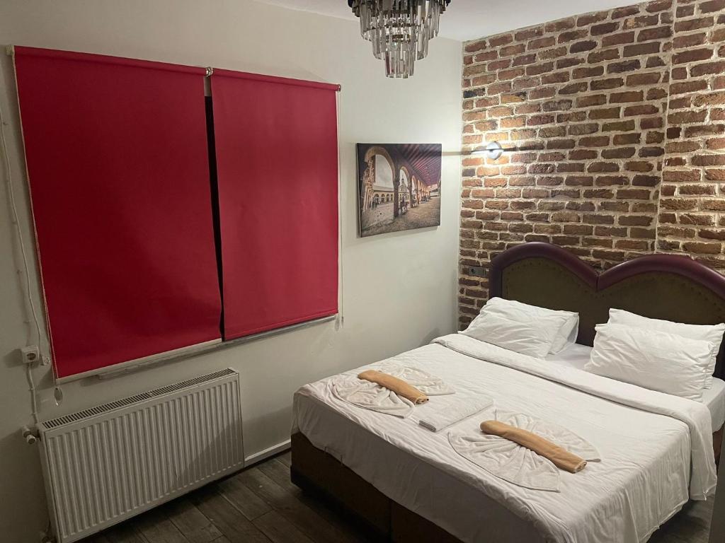 a bedroom with a large bed with a red window at GRAND BELLA VİSTA Hostel in Istanbul