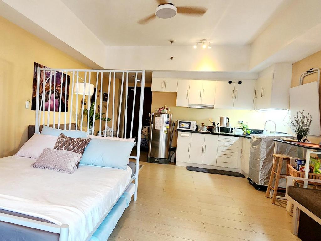 a small kitchen with a bed in a room at 7 pax Maximum Capacity at Cozy Cove Spacious Studio with Balcony at The Venice Grand Canal Mall PARKING ON PREMISE with Pool in Manila