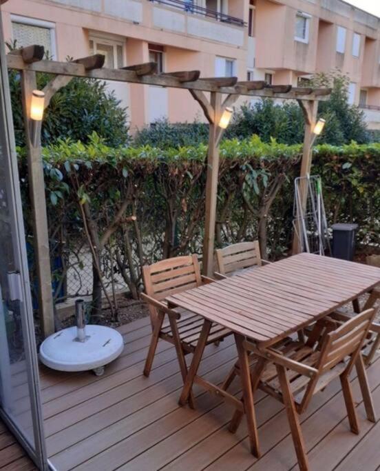 une table et des chaises en bois sur une terrasse en bois dans l'établissement F2 avec Terrasse, Parking gratuit, à Guyancourt