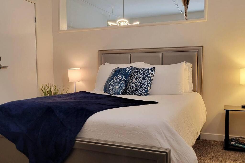 um quarto com uma cama grande e almofadas azuis e brancas em Downtown Azul Loft #3, FREE Parking & Skywalk to Lucas Oil & Conv Center em Indianápolis