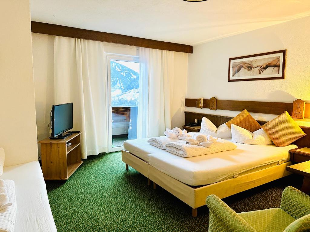 Hotel Marienhof في فليس: غرفه فندقيه سرير وتلفزيون