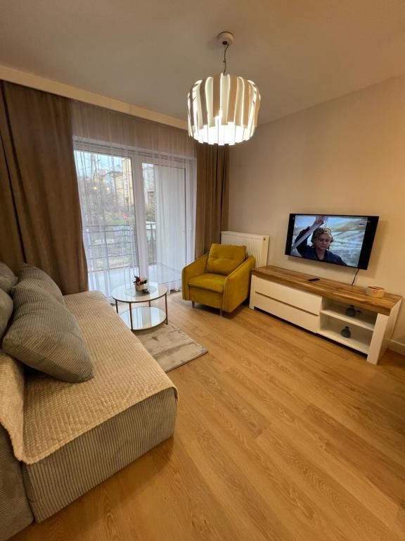 ein Wohnzimmer mit einem Sofa und einem TV in der Unterkunft Apartamenty Alexa Tatarska B in Przemyśl