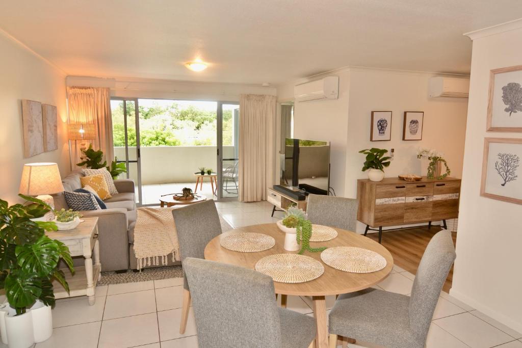 a living room with a table and chairs at City Stadium Apartment 3 in Townsville