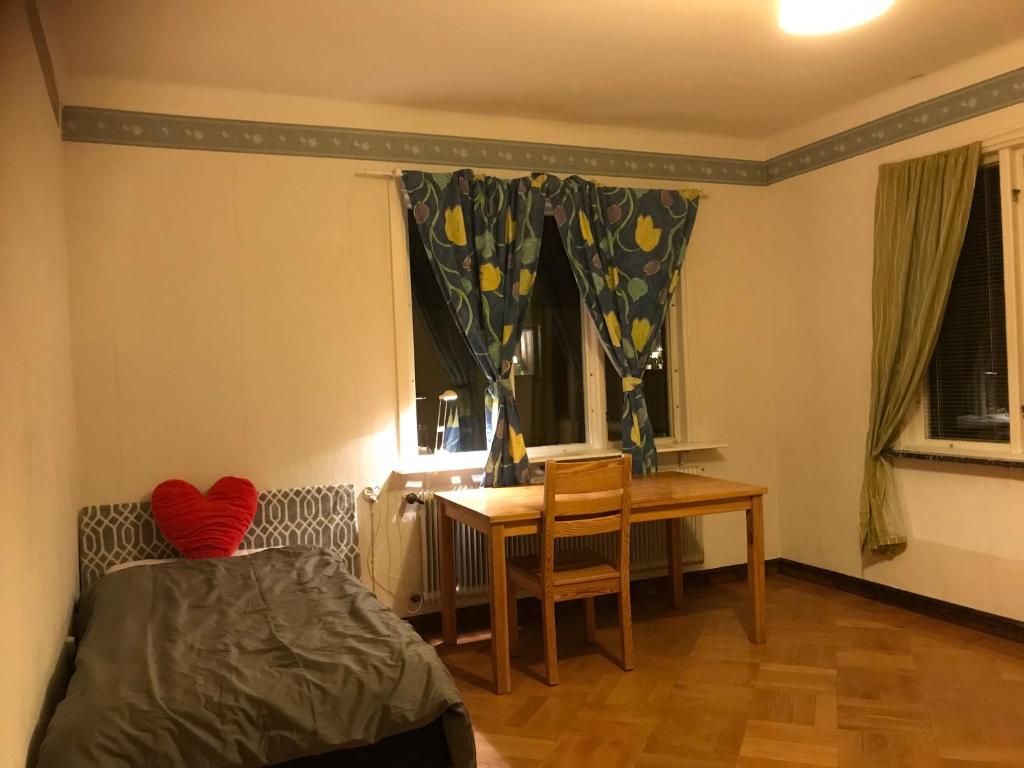 1 dormitorio con cama, mesa y escritorio en Quite house near center, en Eskilstuna
