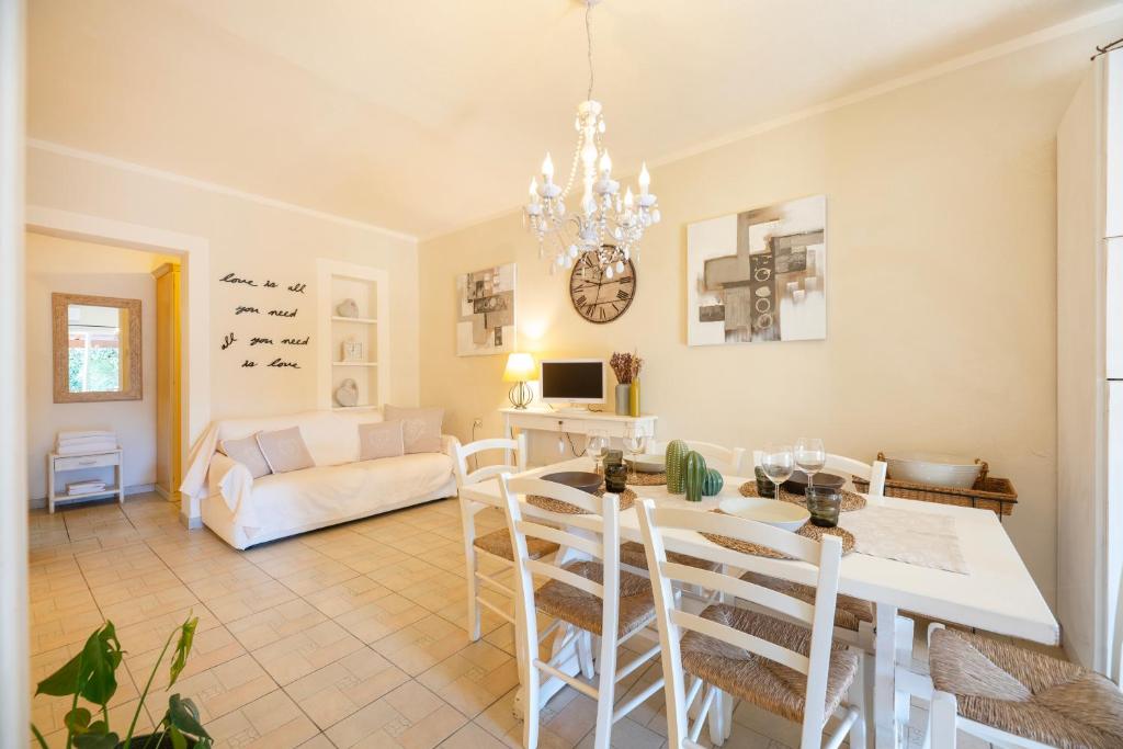 uma sala de jantar e sala de estar com mesa e cadeiras em Maison Elirè - 10 passi dal mare em Capoliveri