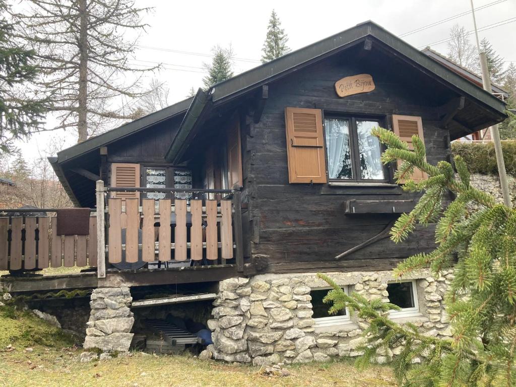 eine Blockhütte mit einer Veranda und einem Fenster in der Unterkunft Entire cozy chalet in St-Cergue - 30 min from Geneva in Saint-Cergue