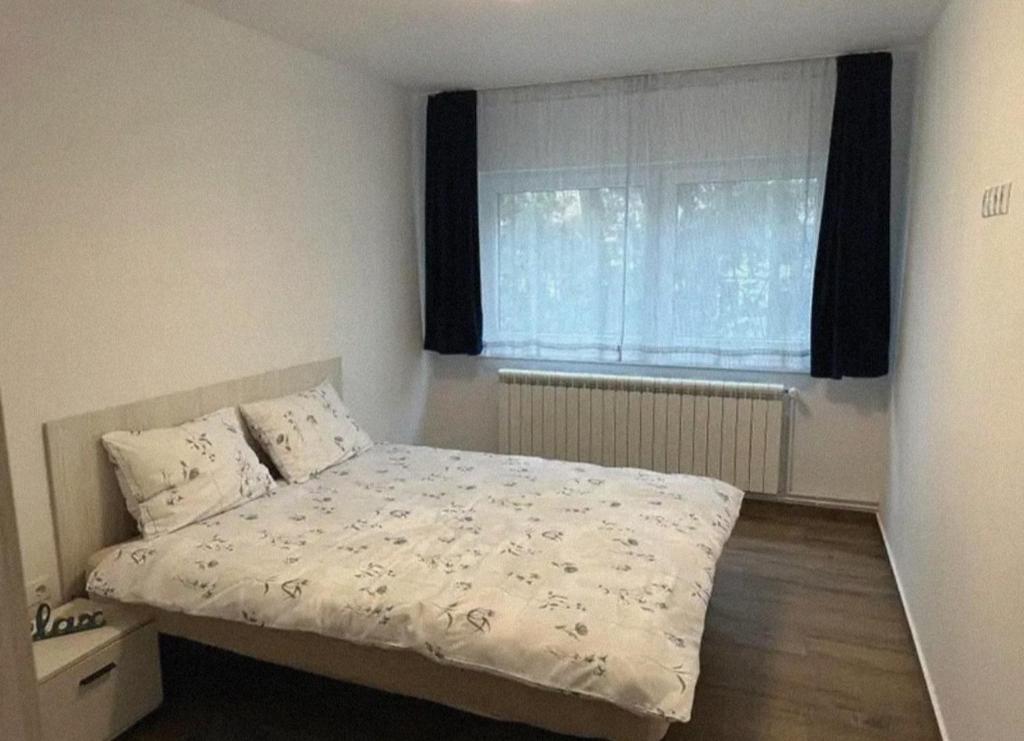 a small bedroom with a bed and a window at Apartment Iris bedroom living and parking voucher vacanță in Baia Mare