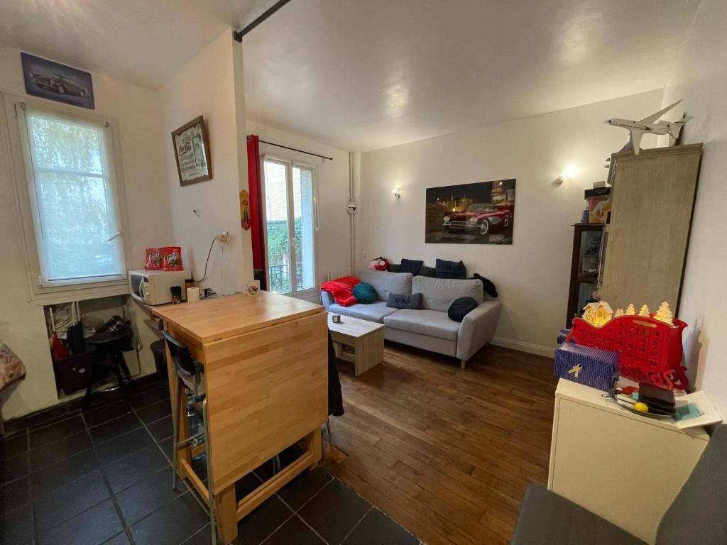 een woonkamer met een bank en een tafel bij Apt 4personnes idéal pour les JO in Boulogne-Billancourt