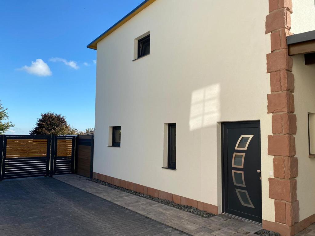 una casa bianca con una porta nera e un cancello di Alte Schlossgärtnerei Bebertal a Bebertal Zwei